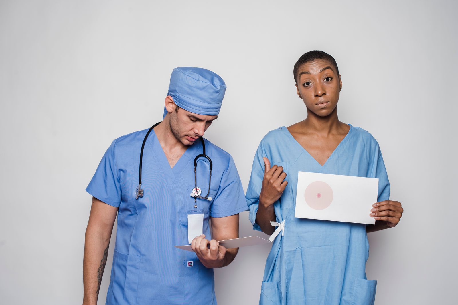 Medical professionals in blue scrubs promoting breast cancer awareness with visual aids.